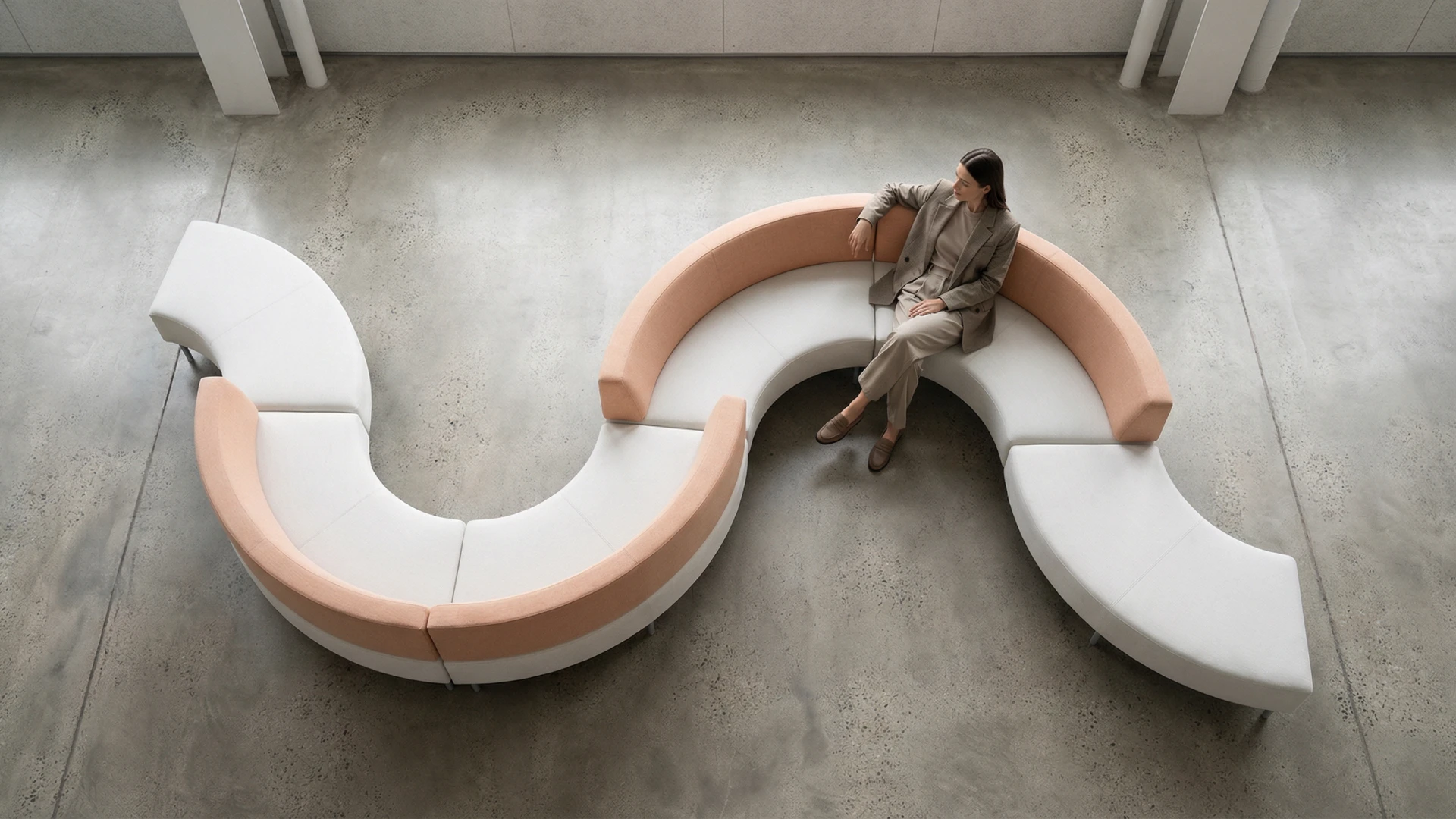 Sofá modular curvo em tons claros em ambiente corporativo, visto de cima